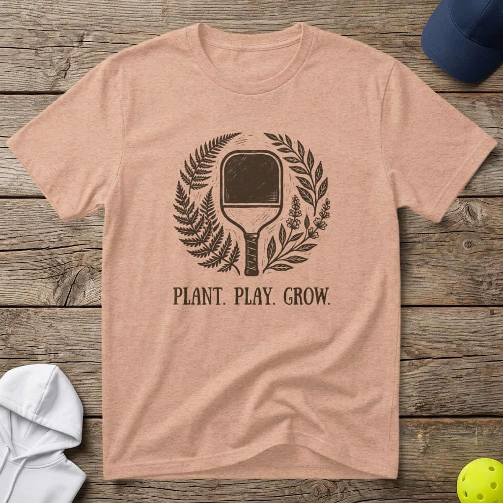 Peach t-shirt with pickleball paddle and greenery, reads "PLANT. PLAY. GROW."