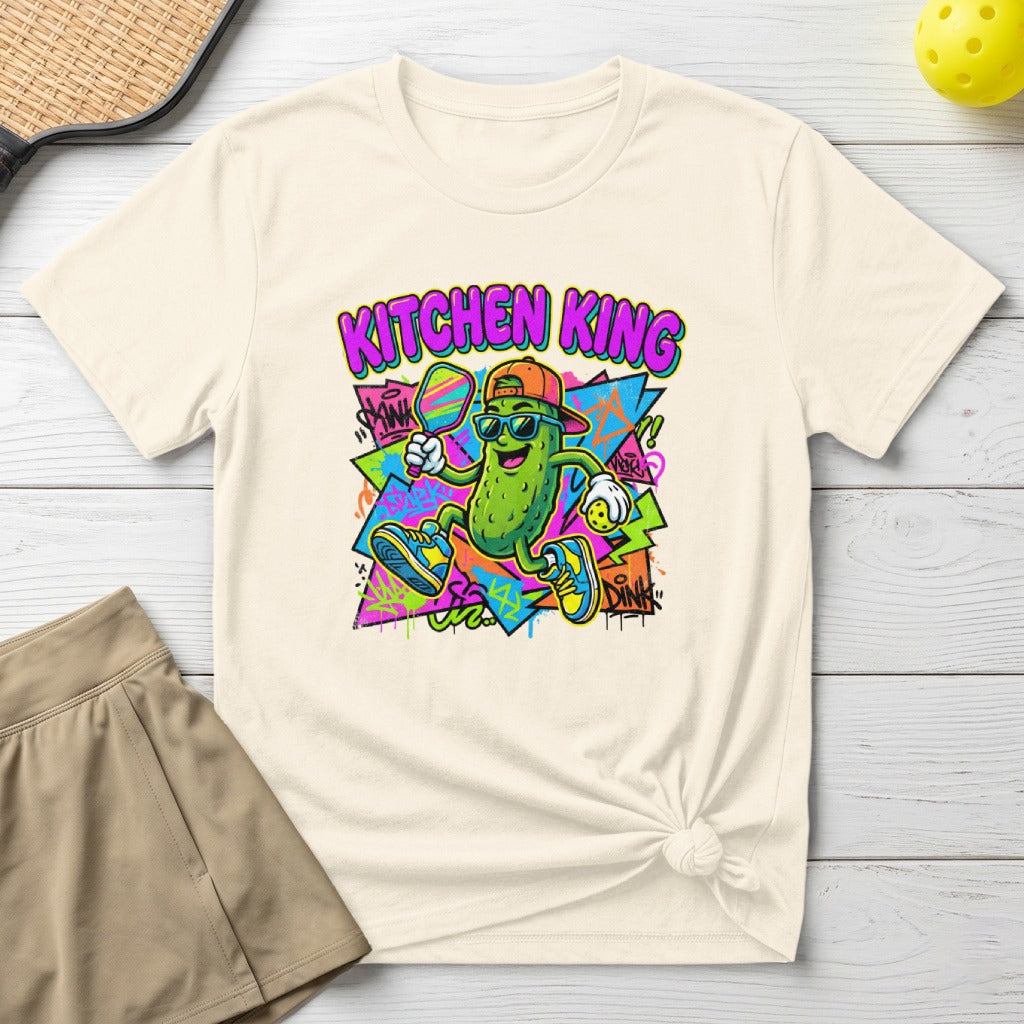 T-shirt with cartoon pickle playing pickleball and text "KITCHEN KING".