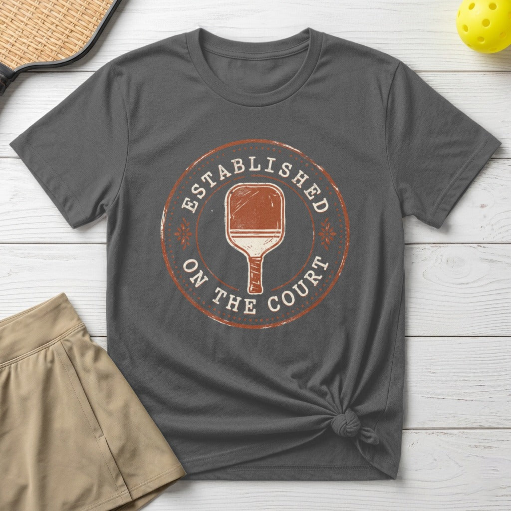 Gray t-shirt with "Established On The Court" and pickleball paddle graphic.