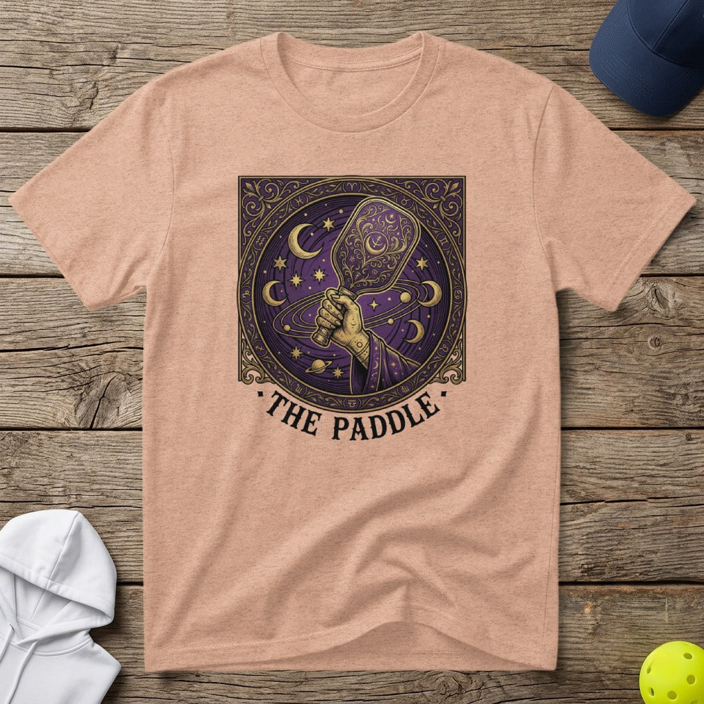 Peach t-shirt with a celestial-themed pickleball paddle graphic and text "The Paddle."