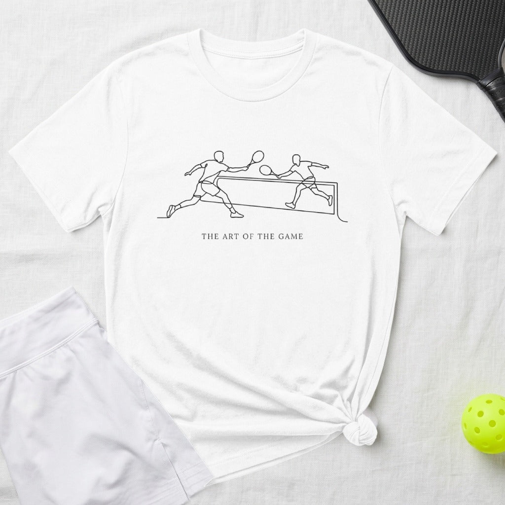 White t-shirt with black line art of pickleball players and "The Art of the Game" text.