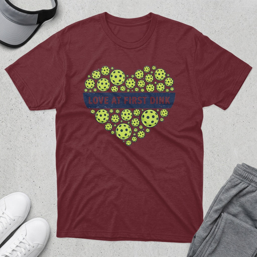 Maroon t-shirt with heart-shaped pickleballs and "LOVE AT FIRST DINK" text.