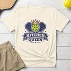 Pickleball graphic with "Kitchen Queen" text, crown, and paddles on a cream t-shirt.