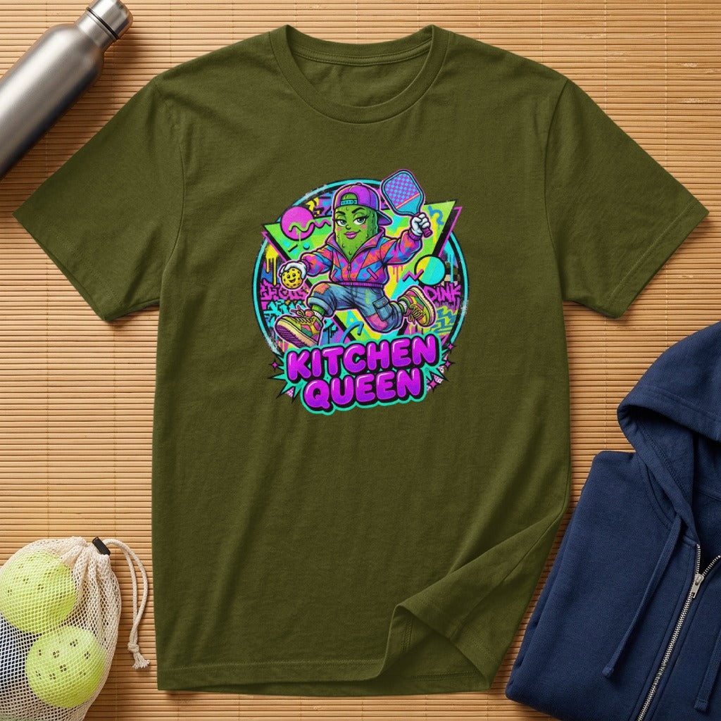 Green t-shirt with cartoon pickle character wearing a crown and holding a pickleball paddle.