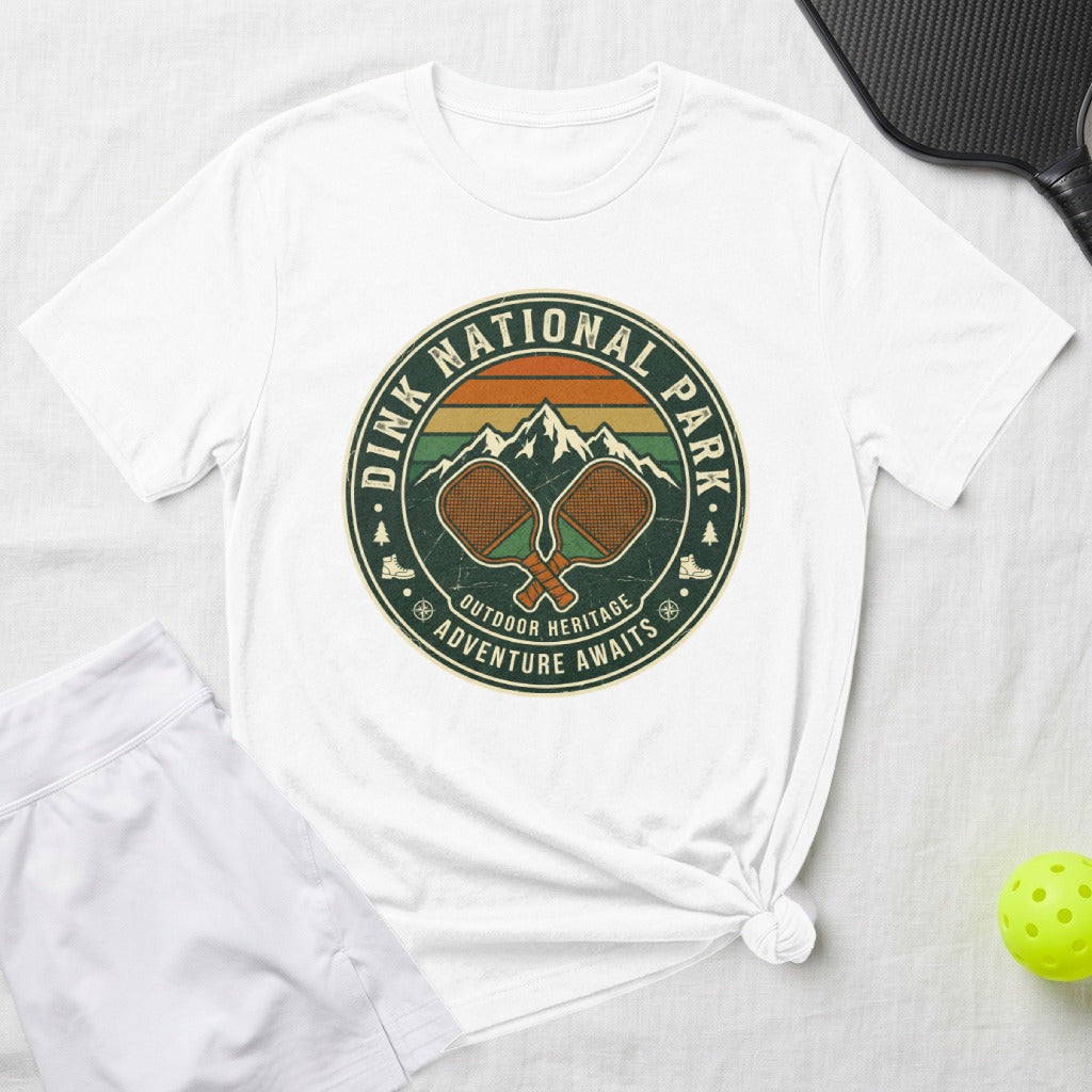 White t-shirt with "Dink National Park" graphic, pickleball paddles, and mountains.