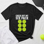 Black t-shirt with "CHECK OUT MY SIX PACK" and six pickleballs.