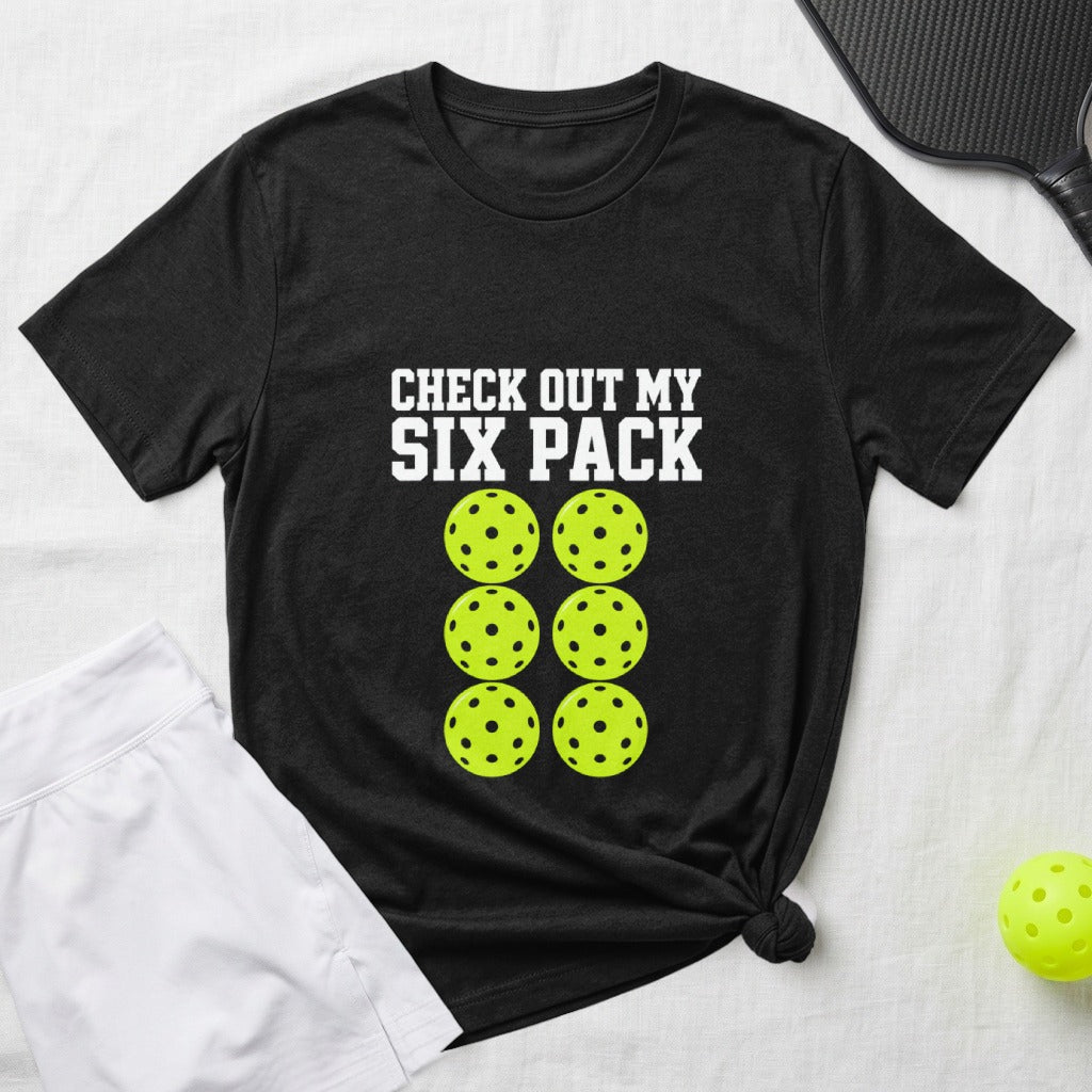 Black t-shirt with "CHECK OUT MY SIX PACK" and six pickleballs.
