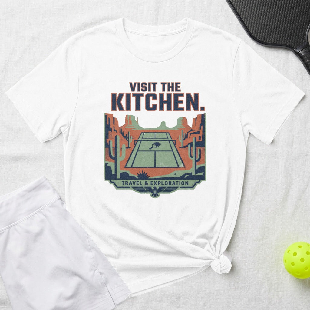 White t-shirt with graphic of pickleball court in desert landscape.