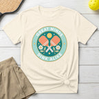 Cream t-shirt with "Great Minds Dink Alike" and crossed pickleball paddles graphic.