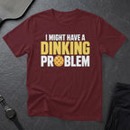 Maroon t-shirt with "I Might Have a Dinking Problem" and pickleball graphic.