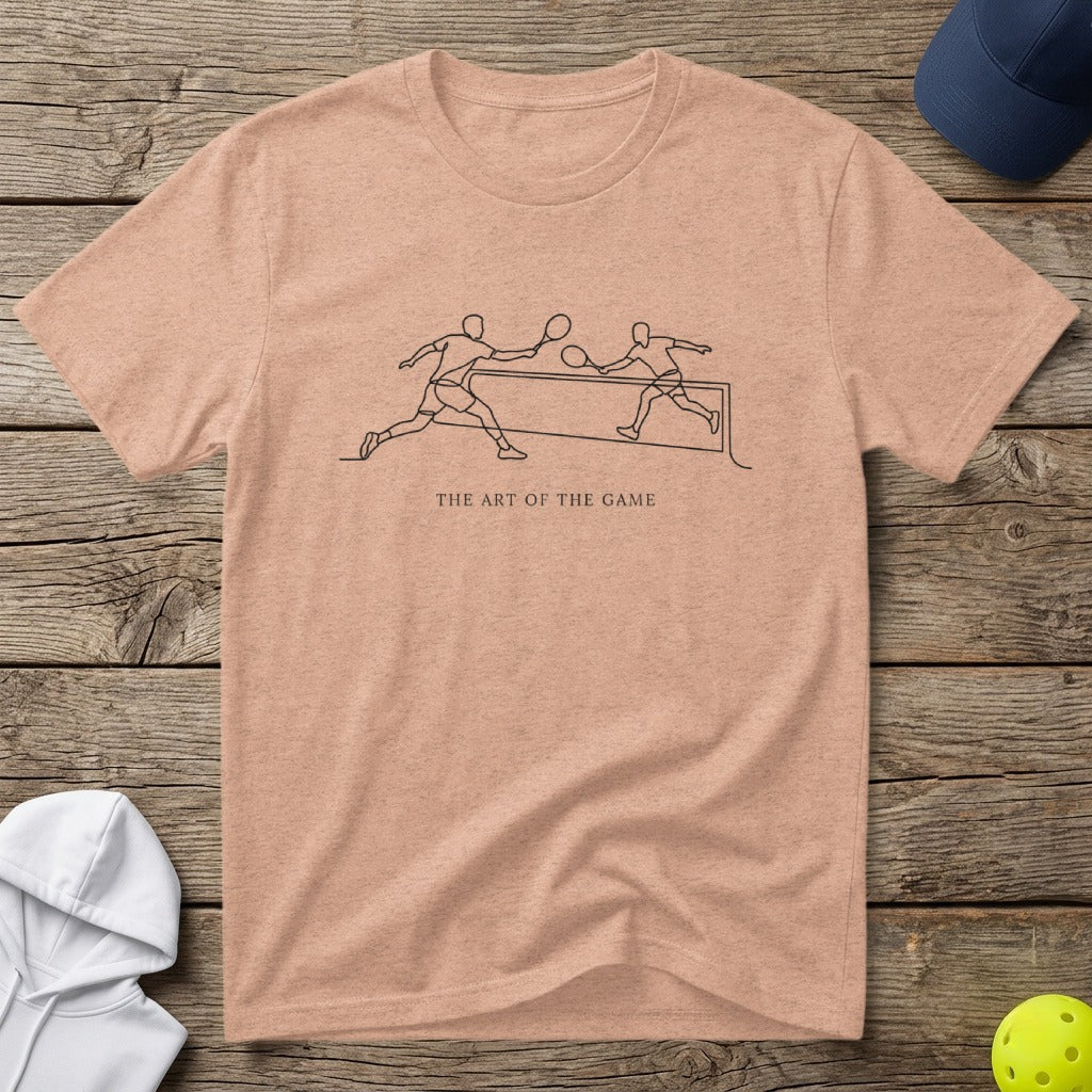 Peach t-shirt with minimalist line drawing of pickleball players and text "The Art of the Game".