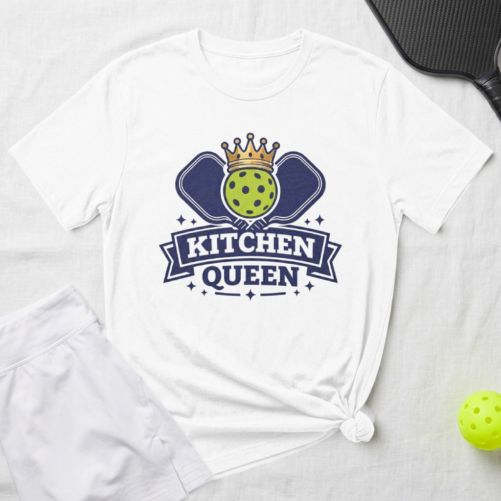 White t-shirt with "KITCHEN QUEEN" and pickleball graphic, alongside shorts and ball.
