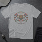 T-shirt with embroidered pickleball paddle, birds, and floral wreath.