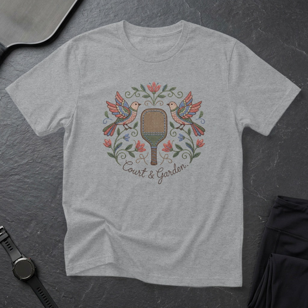 T-shirt with embroidered pickleball paddle, birds, and floral wreath.