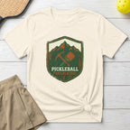 Cream t-shirt with "Pickleball Trailblazers" emblem featuring a paddle and pickaxe.