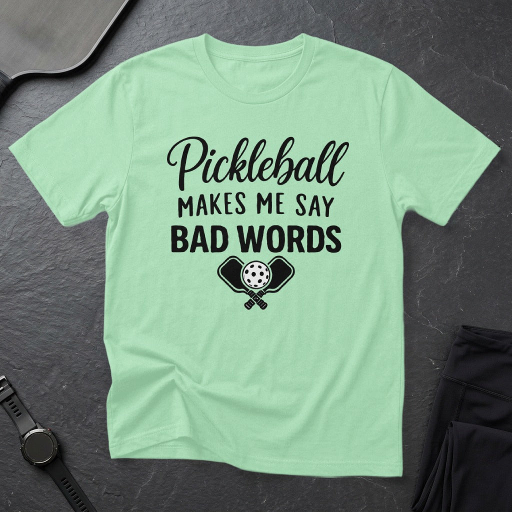 Light green t-shirt with "Pickleball Makes Me Say Bad Words" text and crossed paddles.