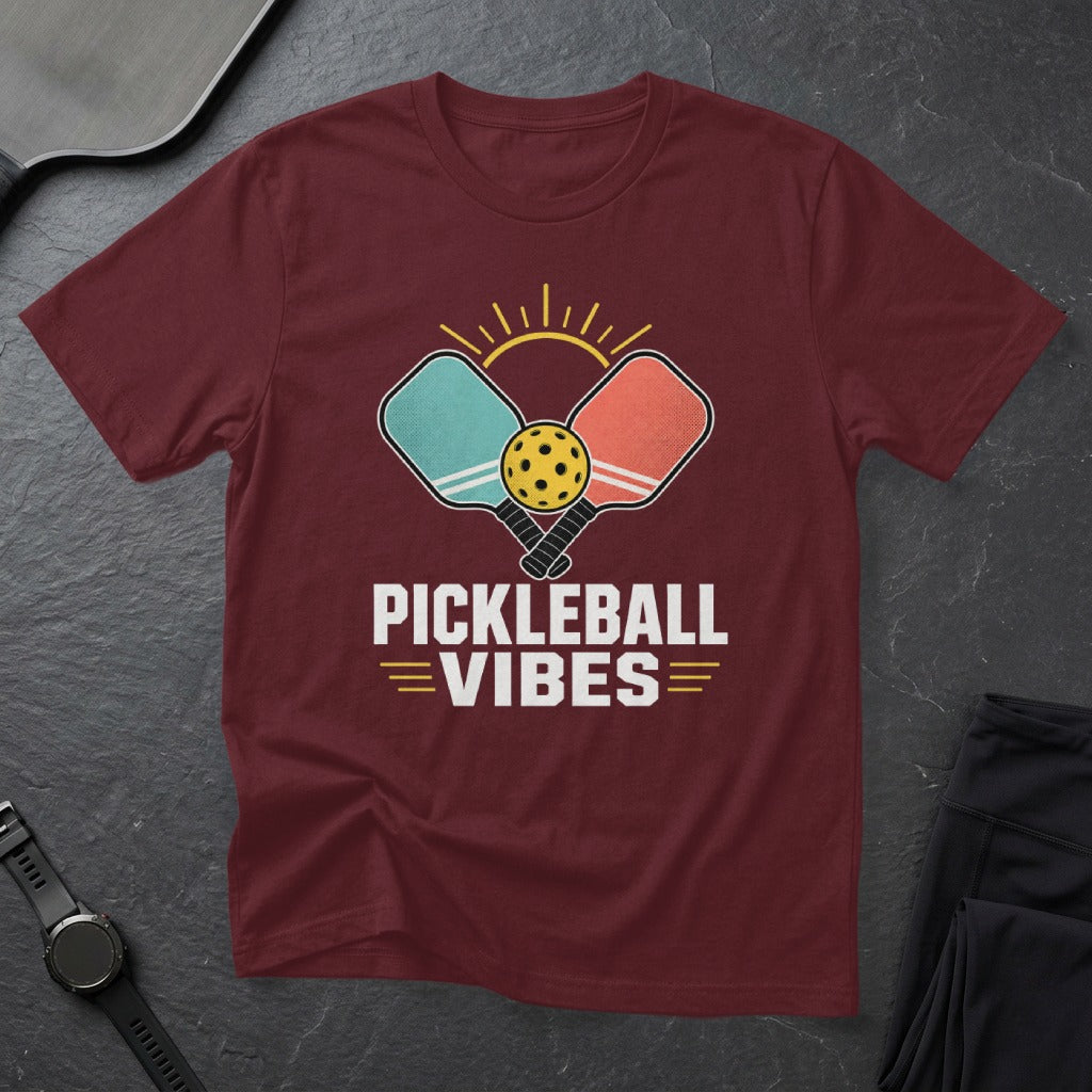 Maroon t-shirt with graphic of pickleball paddles, ball, and sun, text says "PICKLEBALL VIBES".