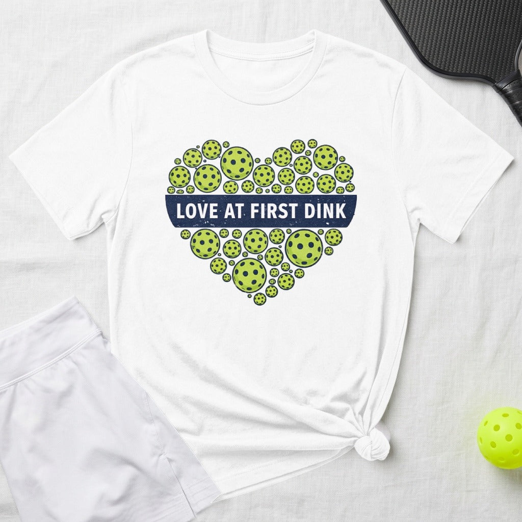 White t-shirt with pickleball heart graphic and "Love at First Dink" text.