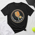 Black t-shirt with pickleball graphic and text "PICKLEBALL IS CALLING ME".