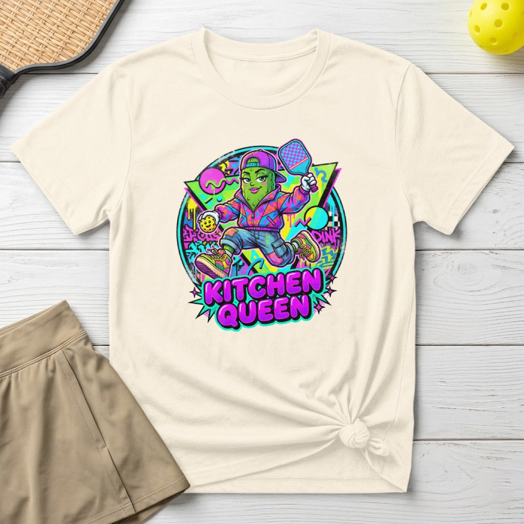 Pickleball queen graphic on a cream t-shirt with a tennis skirt.