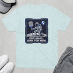 Astronaut kneeling on moon with pickleball paddle, text "One small dink for man."