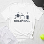 White t-shirt with graphic of pickleball, coffee cup, beer mug, and text "Serve. Sip. Repeat."