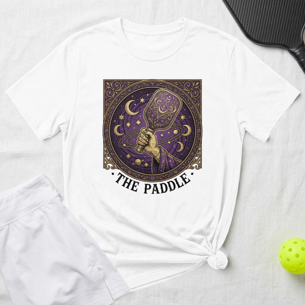 White t-shirt with a celestial pickleball paddle design and "The Paddle" text.