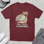 Maroon t-shirt with "Sun, Sand, & Pickleball" graphic featuring a pickleball paddle and palm tree.