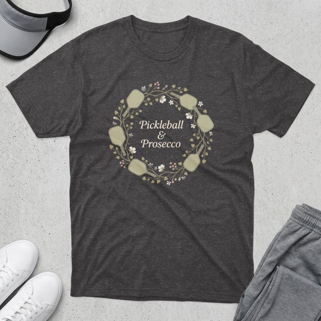 Dark gray t-shirt with a wreath of pickleball paddles, flowers, and text "Pickleball & Prosecco".