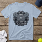 Light blue t-shirt with a circular Viking shield, axes, and the text "Victory or the Kitchen".