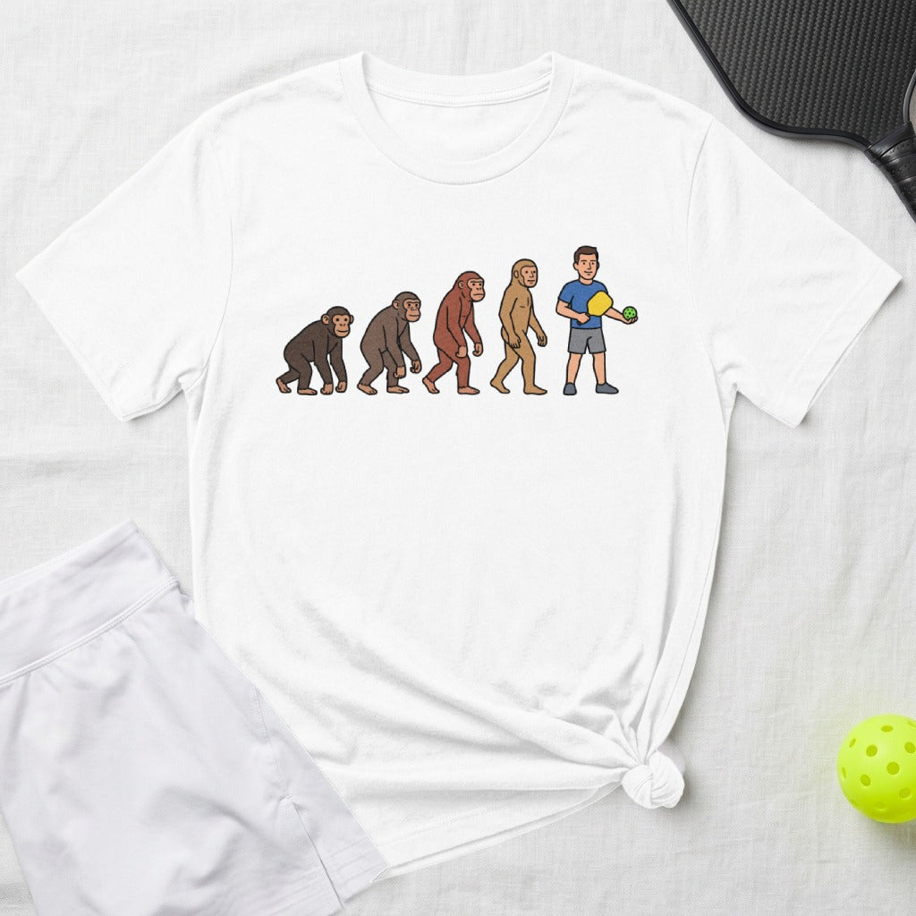 Evolution of man to pickleball player illustration on white t-shirt.