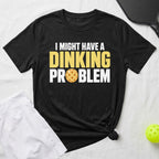 Black t-shirt with yellow text "I MIGHT HAVE A DINKING PROBLEM" and a pickleball.