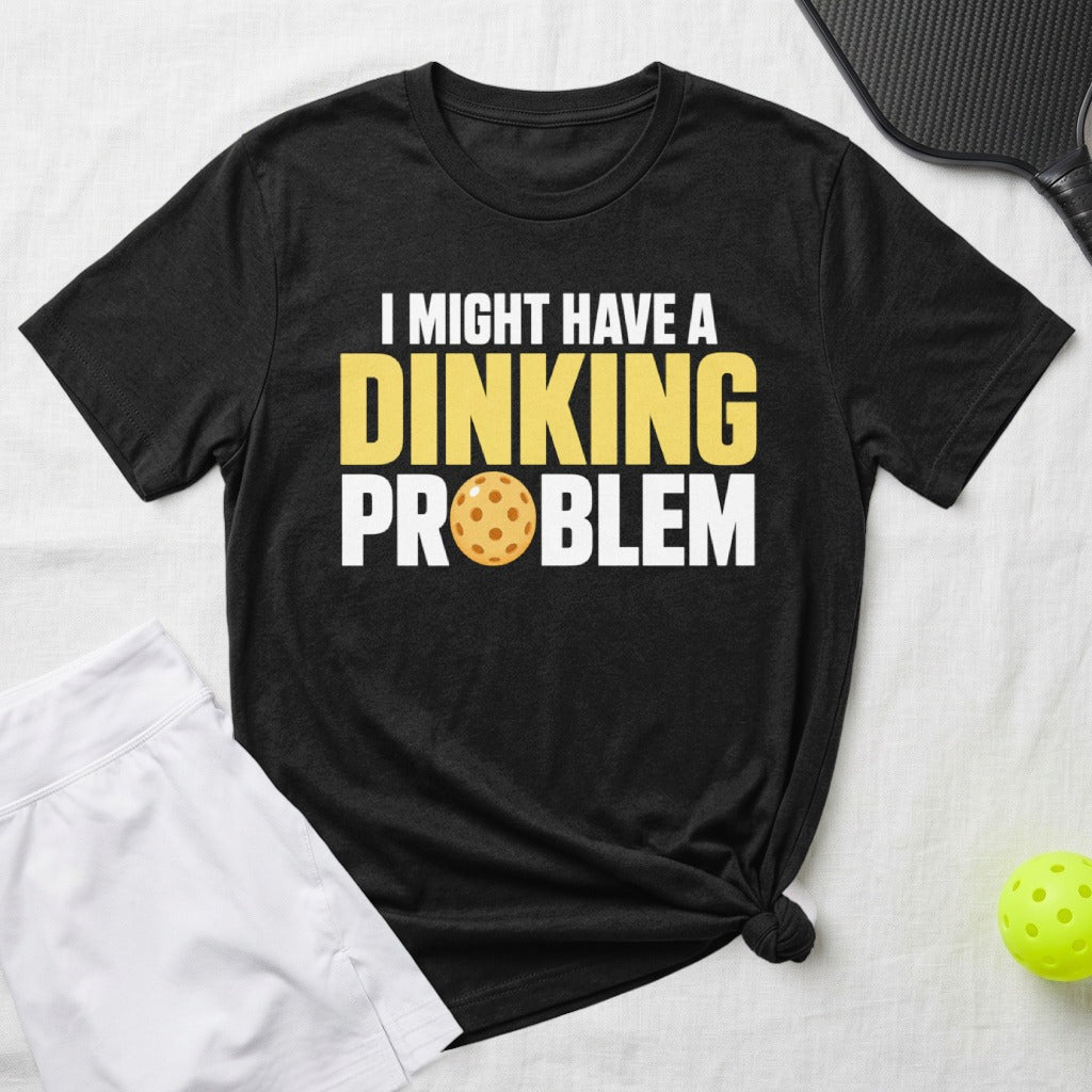Black t-shirt with yellow text "I MIGHT HAVE A DINKING PROBLEM" and a pickleball.