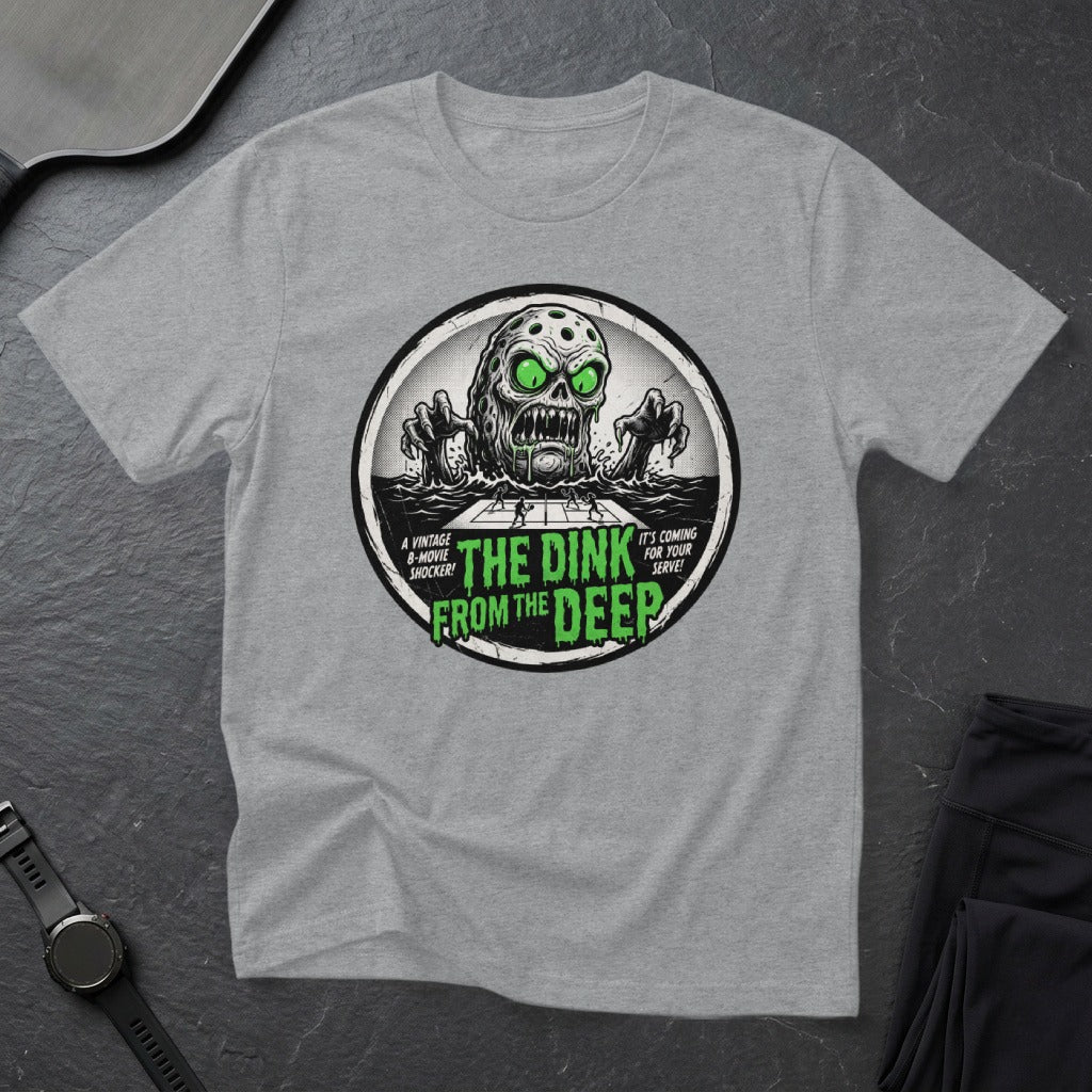 T-shirt with circular graphic of a green-eyed monster rising from water, "The Dink From The Deep" text.