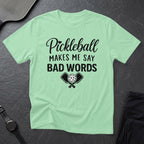 Light green t-shirt with "Pickleball Makes Me Say Bad Words" text and crossed paddles.