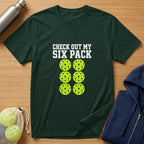 Green t-shirt with "CHECK OUT MY SIX PACK" text and six pickleballs.