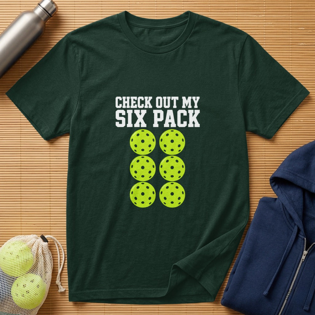 Green t-shirt with "CHECK OUT MY SIX PACK" text and six pickleballs.