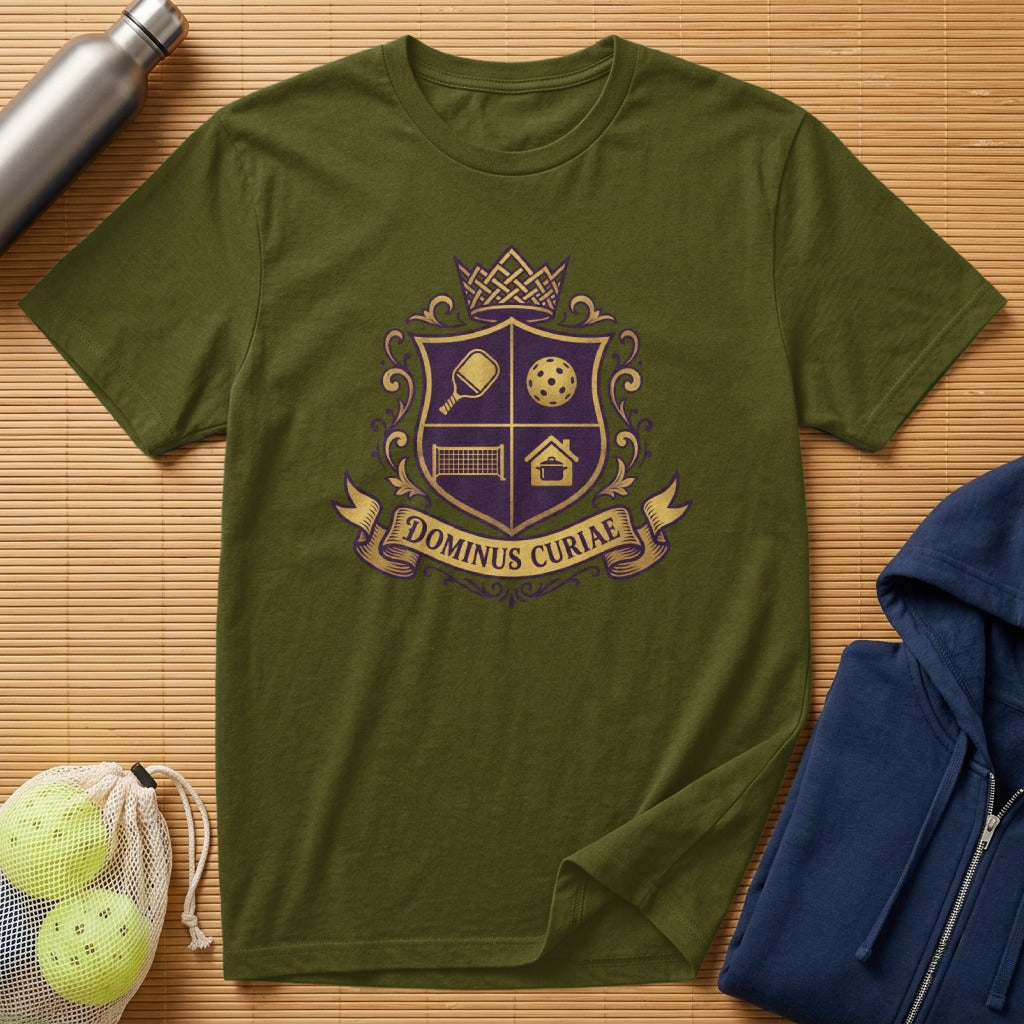 Olive green t-shirt with a purple crest featuring pickleball, house, and crown motifs.