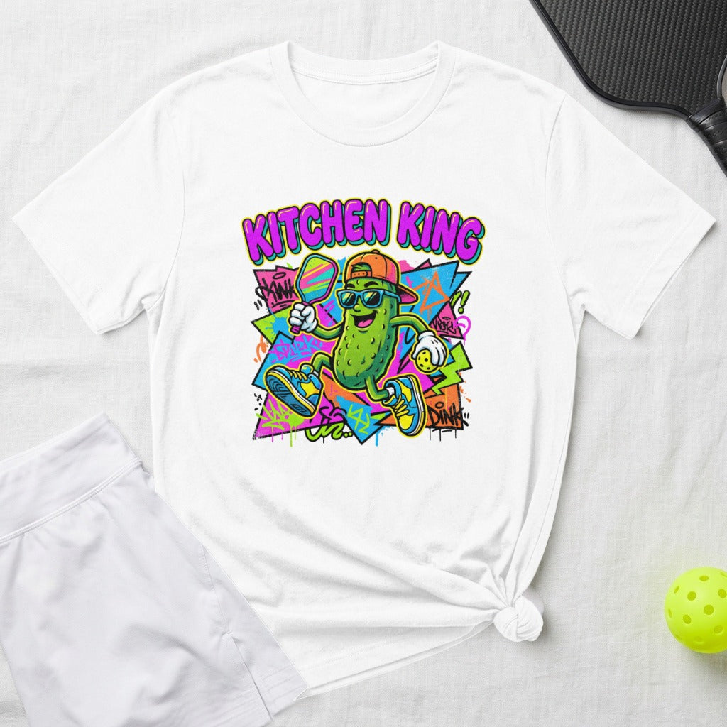 Cartoon pickle wearing sunglasses playing pickleball with "Kitchen King" text.