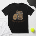 T-shirt with stack of books about pickleball, "A Tale of Two Dinks" title.