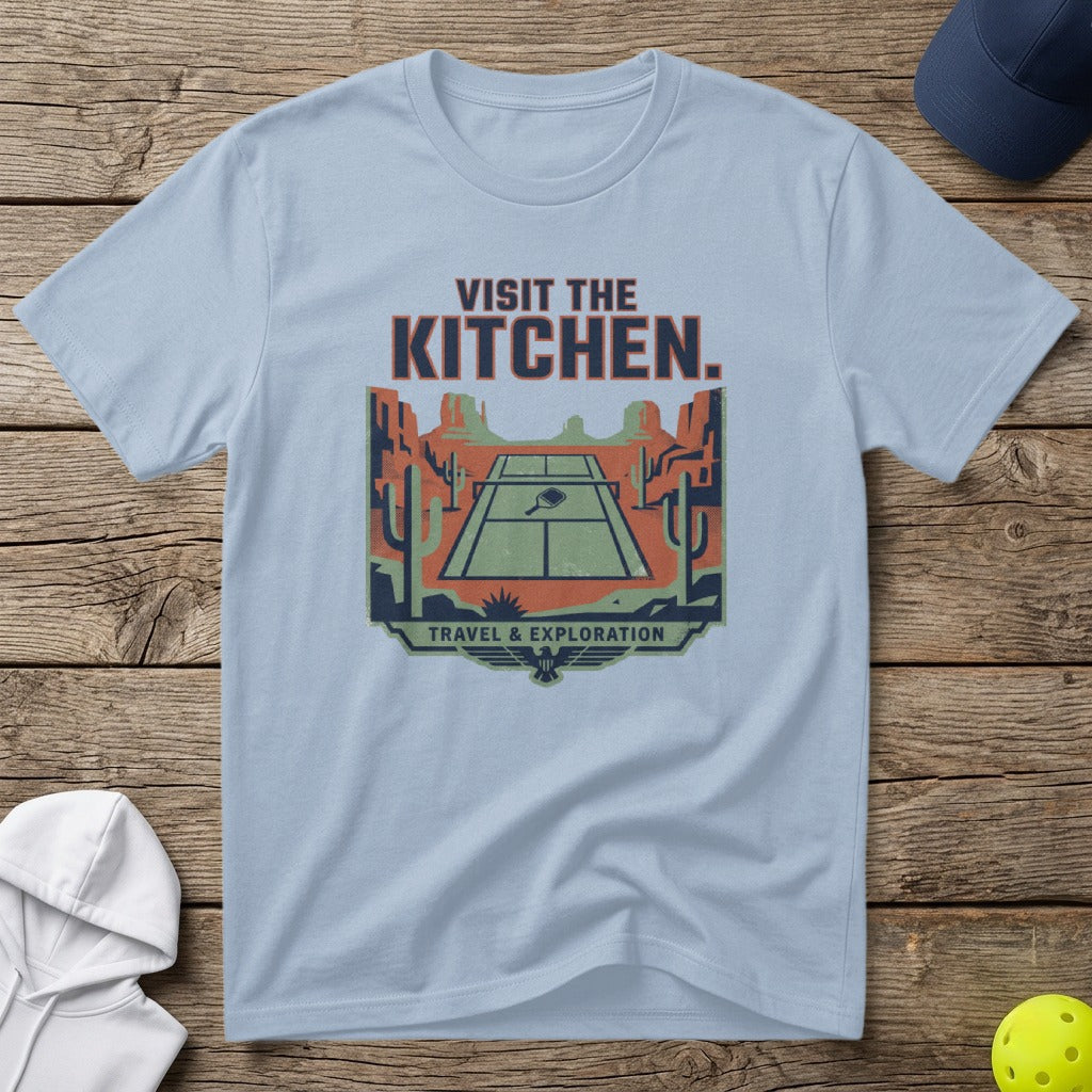 Light blue t-shirt with "VISIT THE KITCHEN" and desert tennis court graphic.