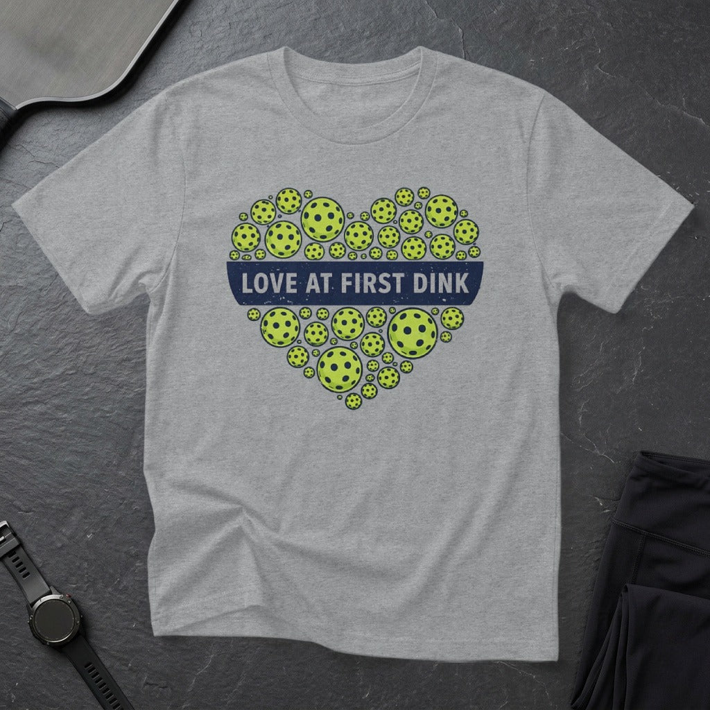 Gray t-shirt with heart shape made of pickleballs and text "Love at First Dink".