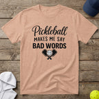 Peach t-shirt with black text: "Pickleball makes me say bad words" and crossed paddles.