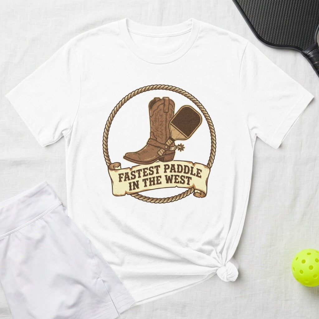 White t-shirt with a cowboy boot, spur, and pickleball paddle graphic.