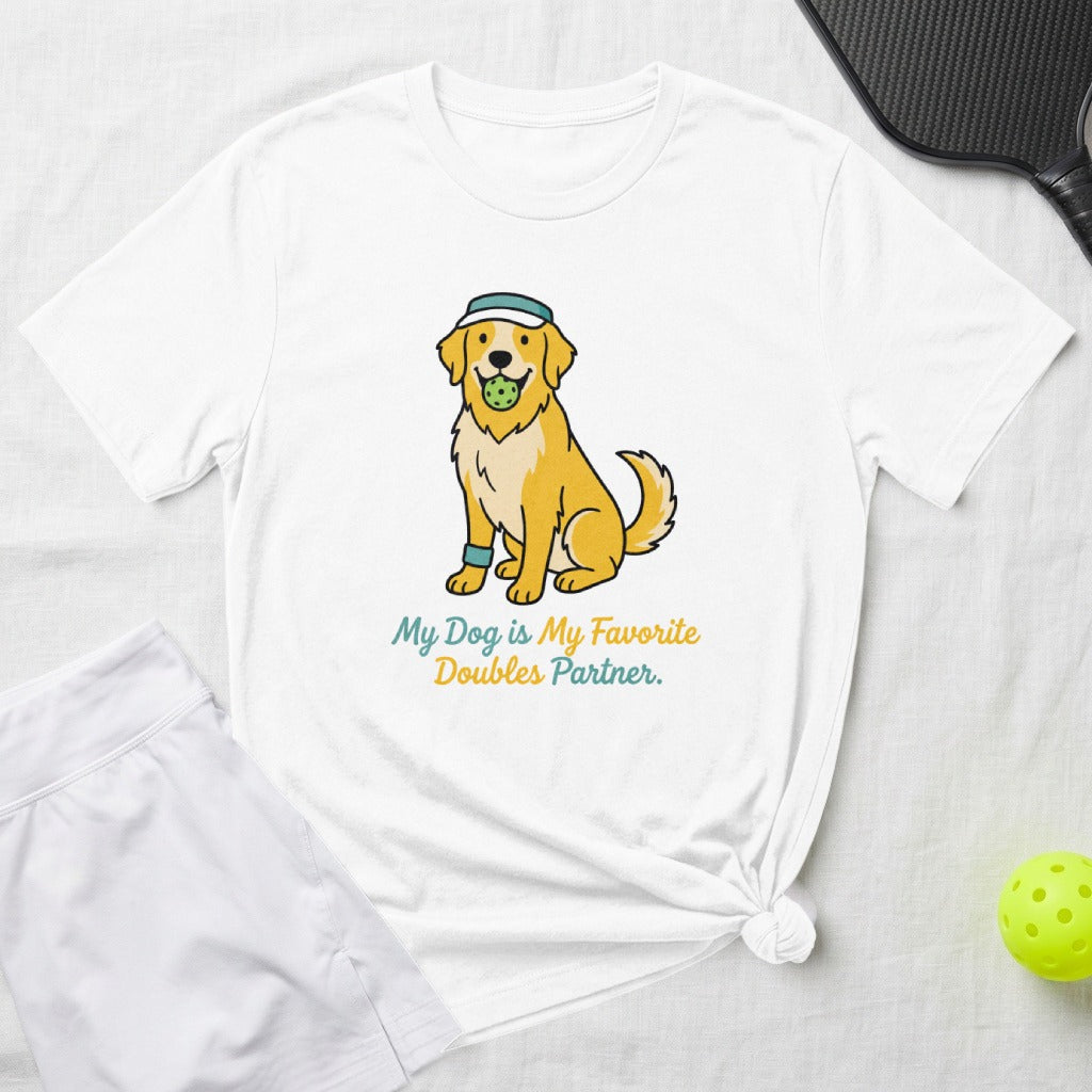 White t-shirt with illustration of a golden retriever holding a pickleball.
