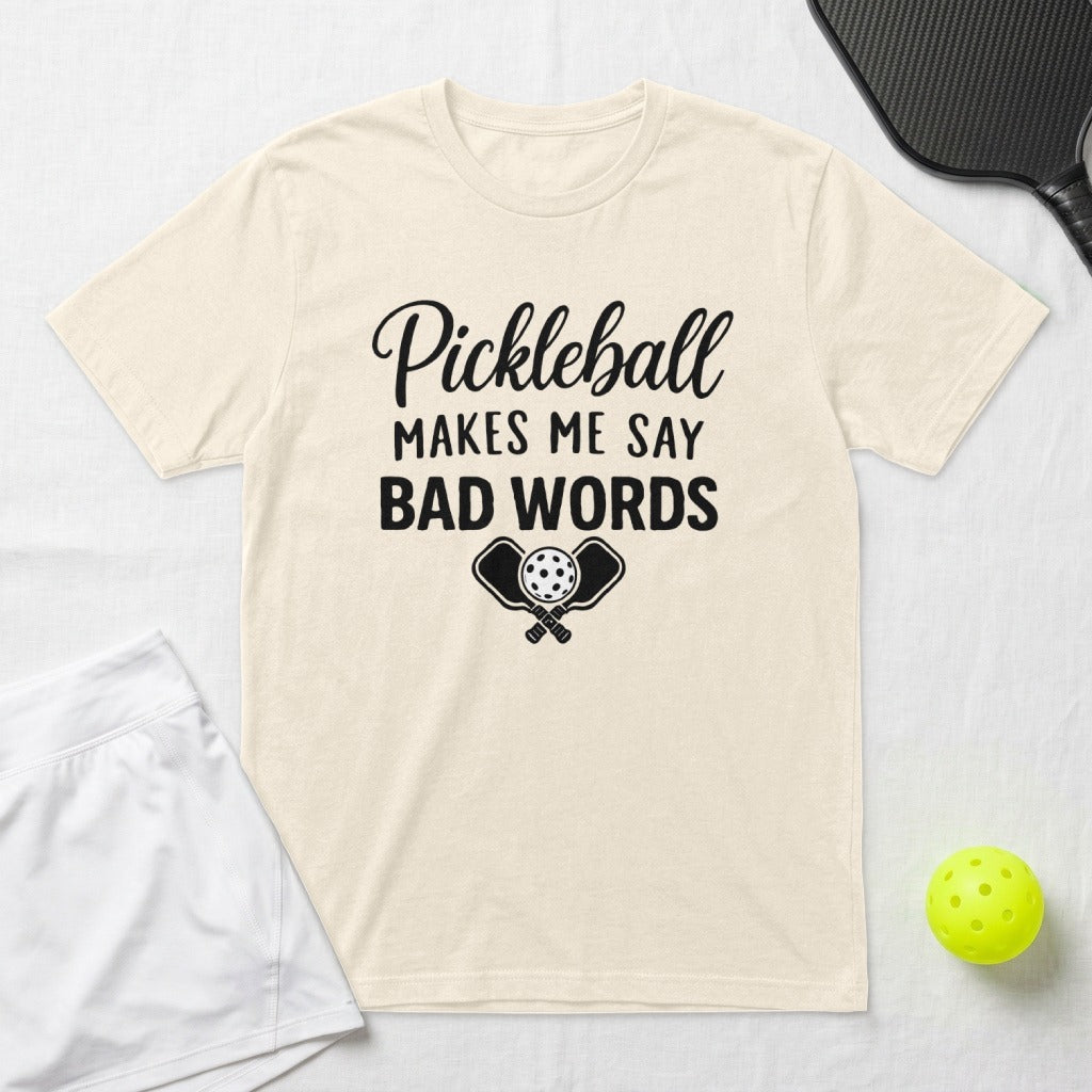 Cream t-shirt with "Pickleball Makes Me Say Bad Words" graphic and crossed paddles.