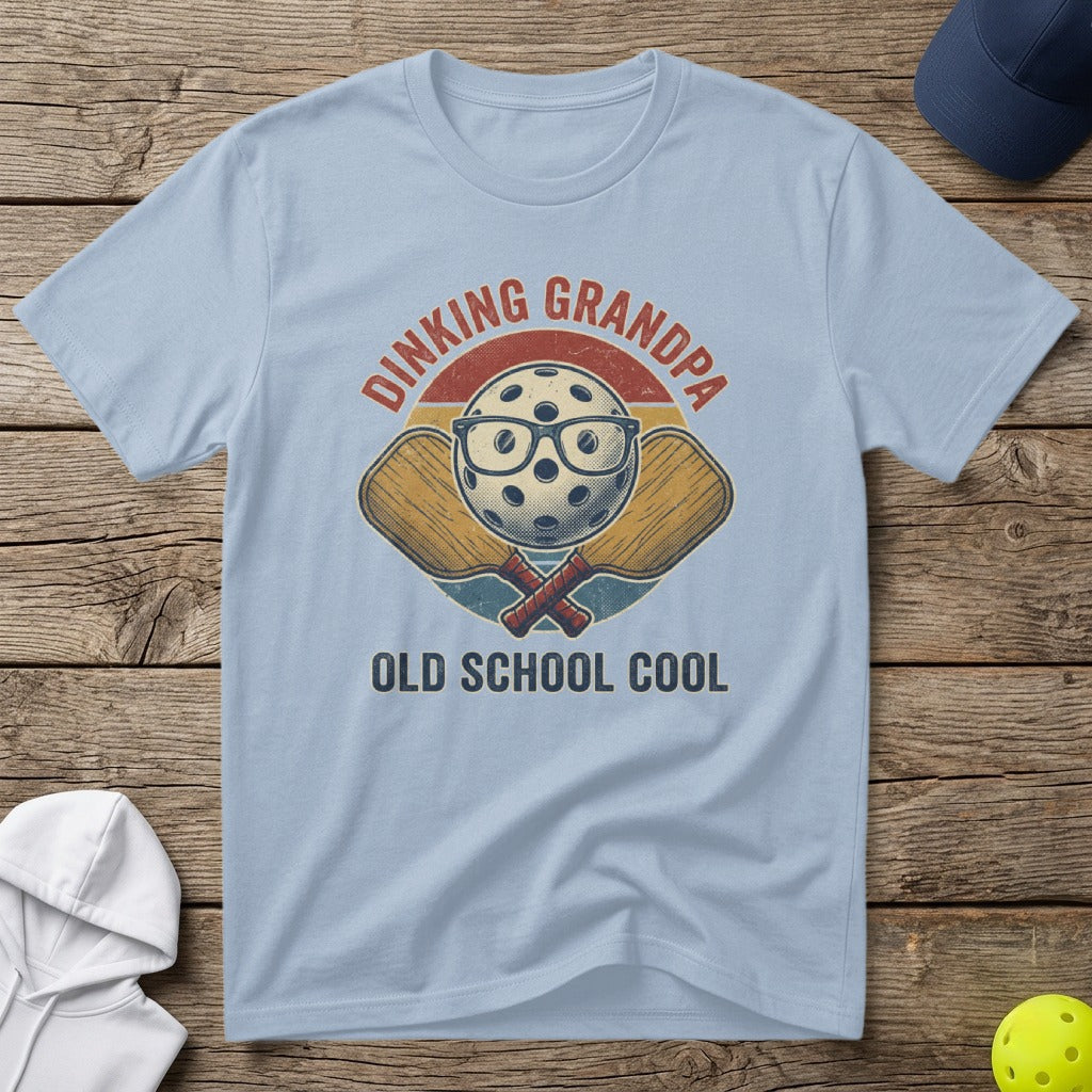 Light blue t-shirt with "DINKING GRANDPA OLD SCHOOL COOL" text and crossed pickleball paddles.