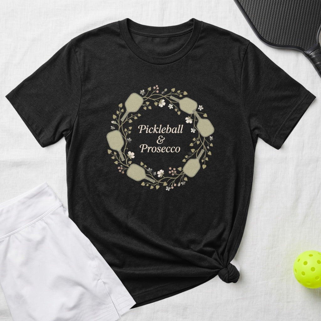 Black t-shirt with "Pickleball & Prosecco" in a floral wreath graphic.