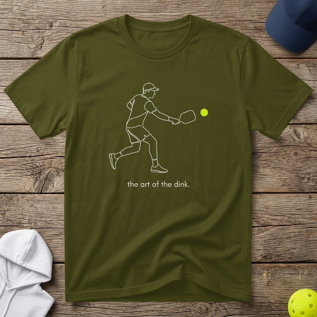 Olive green t-shirt with a line drawing of a pickleball player and "the art of the dink" text.