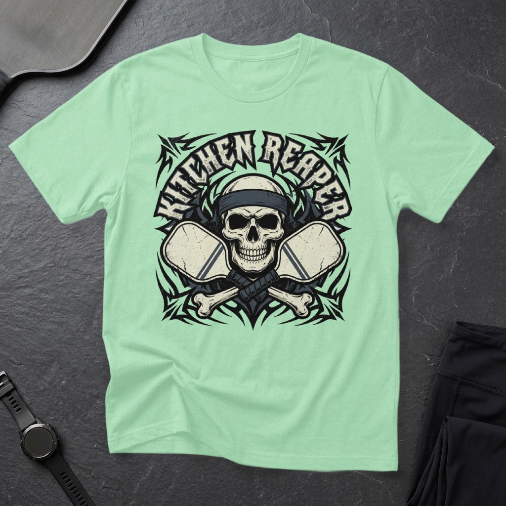 Mint green t-shirt with skull, crossbones, and pickleball paddles graphic.